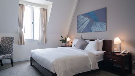 A bedroom with a large bed and a large window near it | Studio | Central Mansions, Phnom Penh
