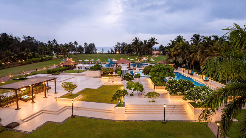 Elevated dusk view of manicured gardens and illuminated pathways at Kenilworth Resort & Spa, Goa.