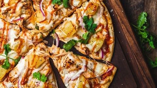 A pizza with various toppings on a wooden board.