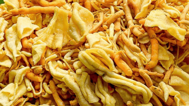 A top view of an assorted farsan platter, showcasing a delightful array of crispy snacks, vibrant colors, and tempting textures.