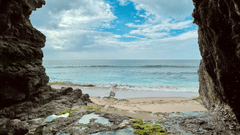 Natural cave located near a clear blue sea