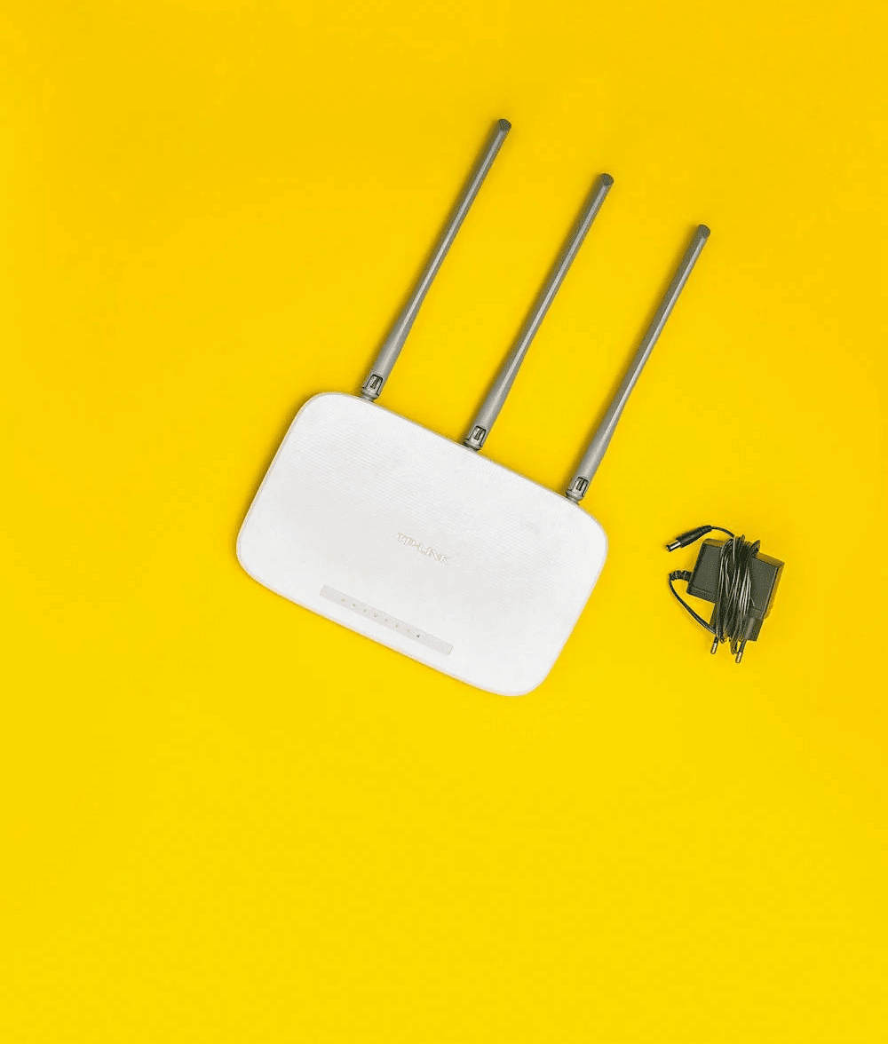 Image of a Wi-Fi router with an adapter on the side. 