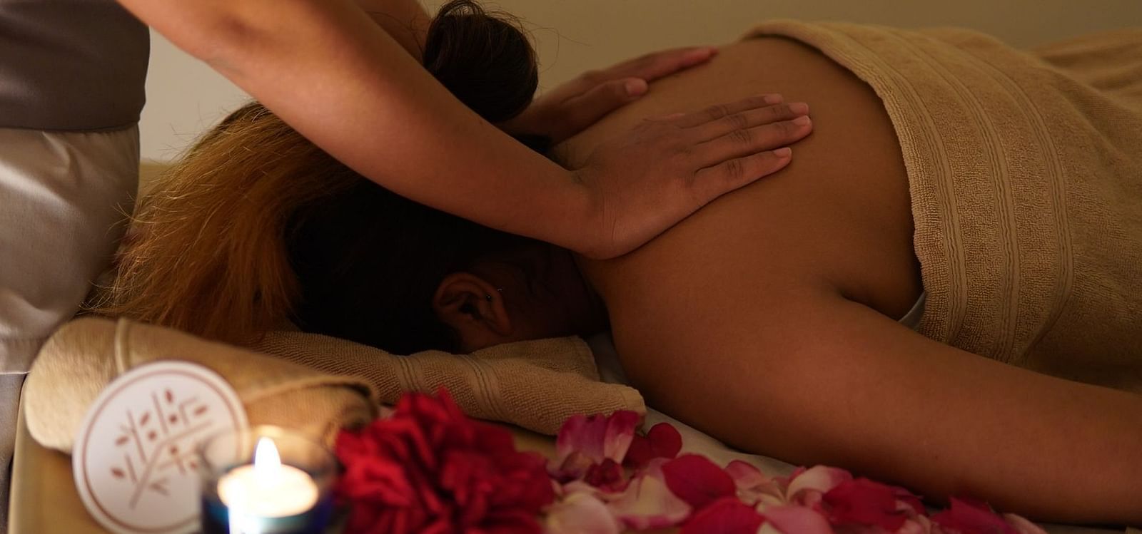 A person lying on their back with their face on a towel getting a back massage
