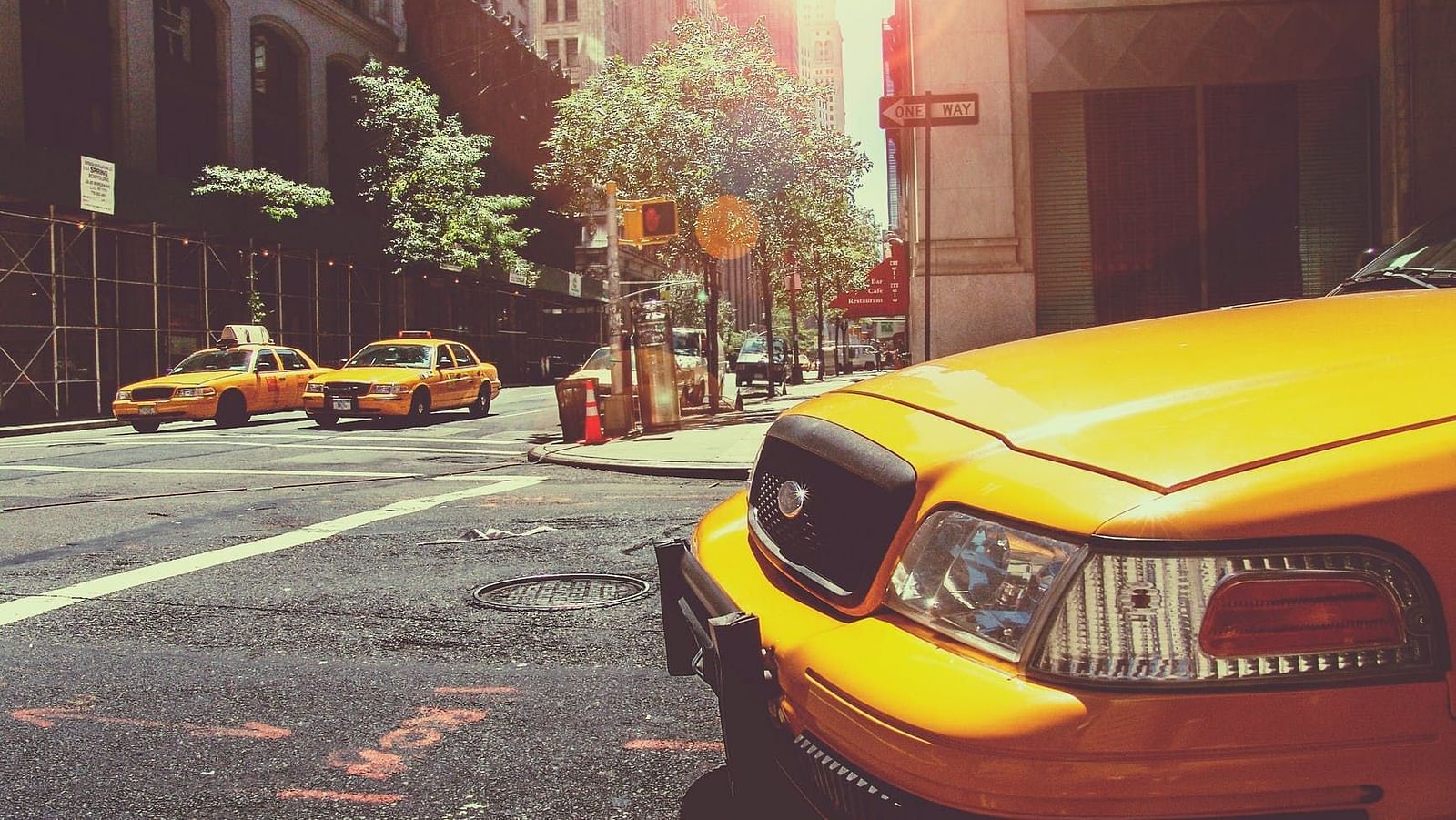 Image of the hood of a car with buildings in the background.