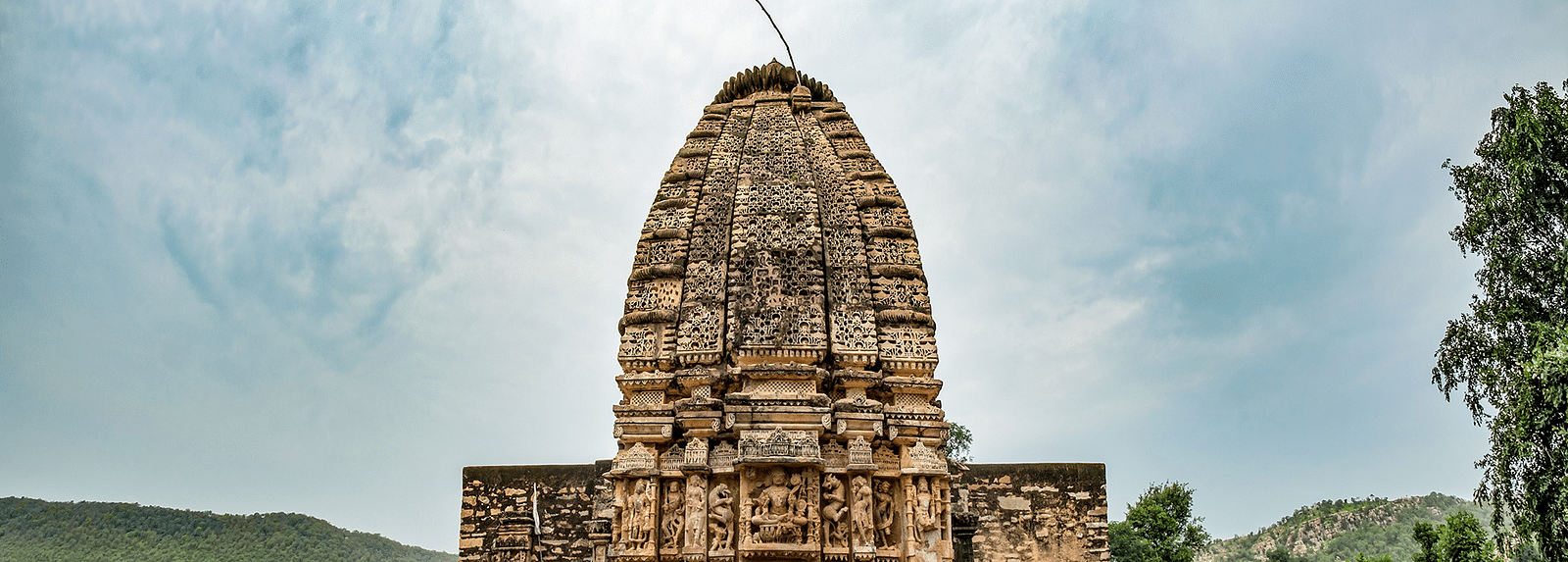 An image of Neelkanth temple with a mountain backdrop and a clear sky