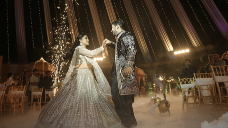 A bride and groom performing a first dance on stage with cold fire sparklers and smoke effects - DAN Resorts & Weddings, Palghar