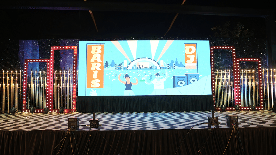 Professional event stage featuring a large central LED screen and vibrant stage lighting - DAN Resorts & Weddings, Palghar