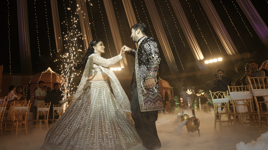 A bride and groom performing a first dance on stage with cold fire sparklers and smoke effects - DAN Resorts & Weddings, Palghar
