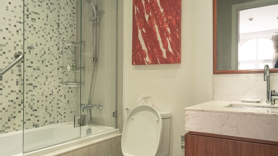 A bathroom with a toilet, a sink, and a shower | Two-bedroom Suite | Central Mansions, Phnom Penh