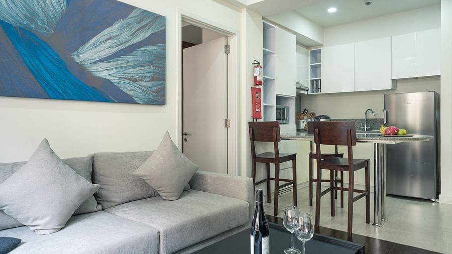 A living room with a sofa, a coffee table, and a dining area | Two-bedroom Suite | Central Mansions, Phnom Penh