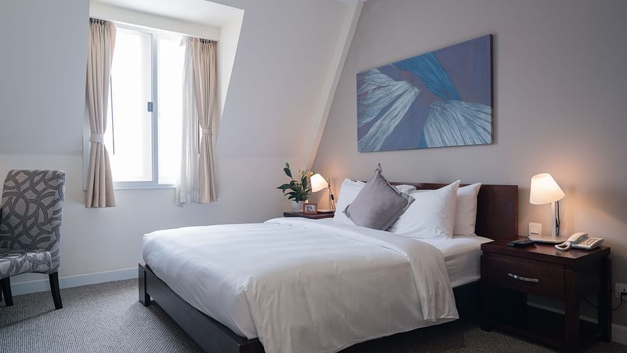 A bedroom with a large bed and a large window near it | Studio | Central Mansions, Phnom Penh