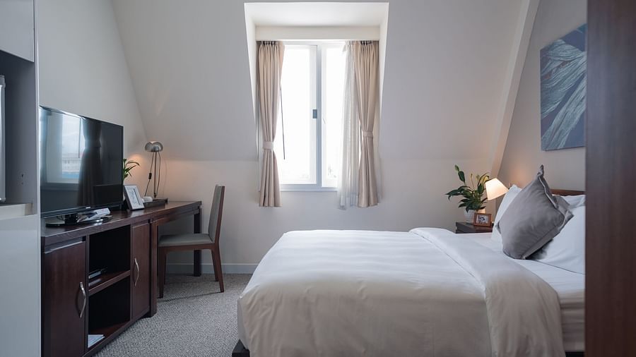 A bedroom with a bed, a desk, and a television | Studio | Central Mansions, Phnom Penh