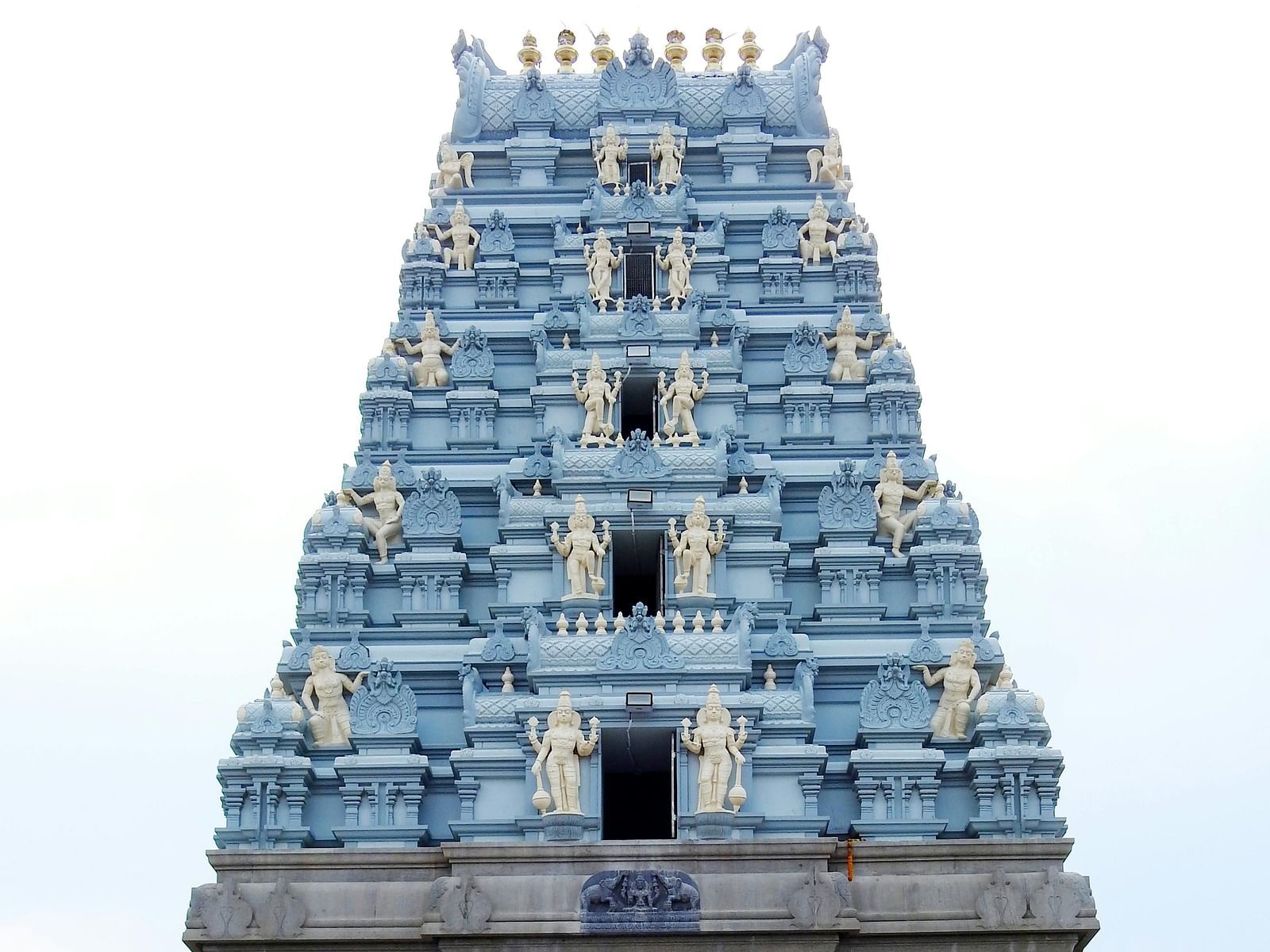 Intricately carved stone temple facade, showcasing detailed sculptures and ornate designs, reflecting exquisite craftsmanship.