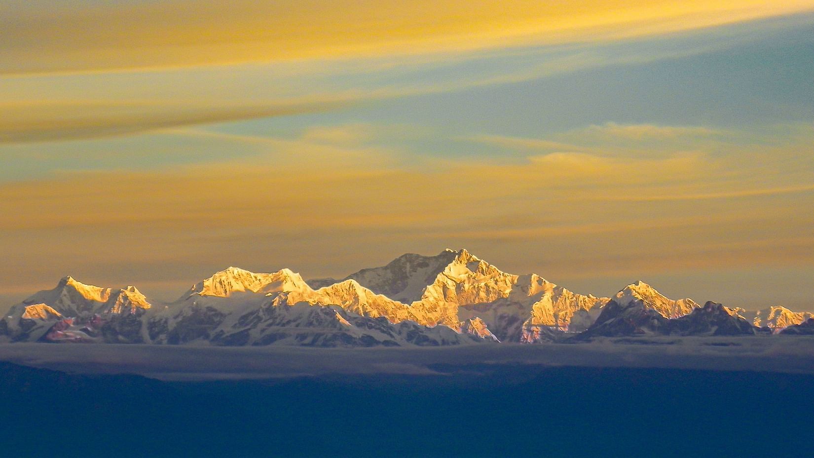 snow covered mountains with clouds above 