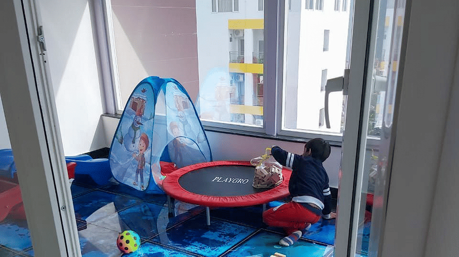 A toddler playing inside the Kids' Play Area with a small trampoline besides him at DLS Hotels On The Ganges.