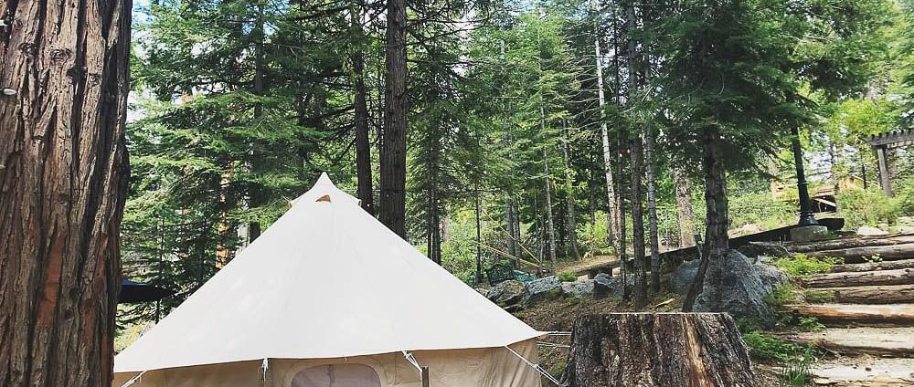 Exterior of a tent at Shaver Lake Village Hotel surrounded by trees.