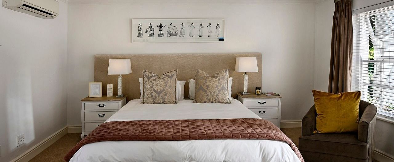 Well-lit, modern bedroom with a king size bed and neutral decor.