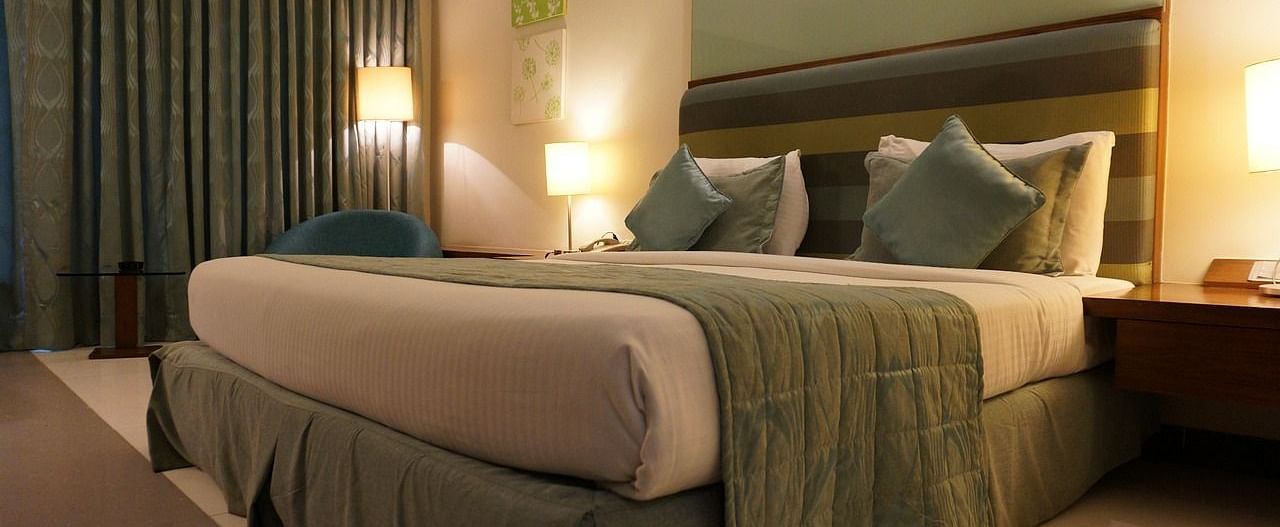 Image of a bedroom with a large bed, side tables, and lamps.