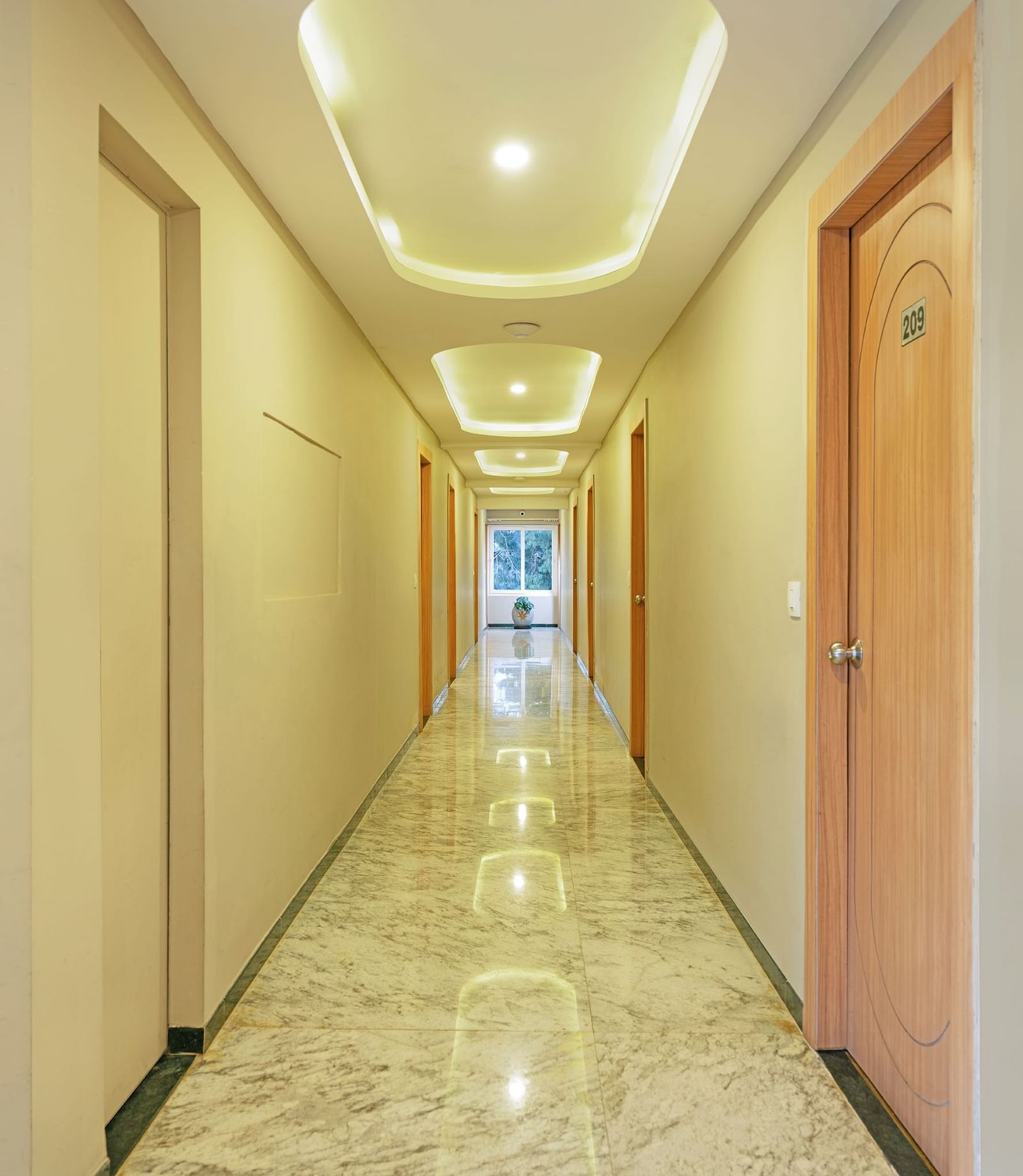 Long corridor in a modern building with marble floors and ceiling lights | Mango HIll Central, Ooty