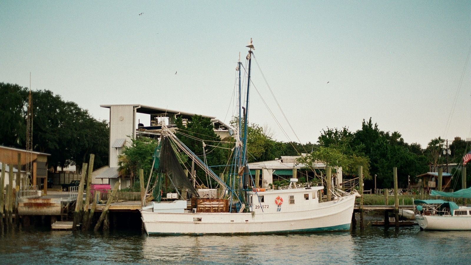 An overview of a pier with a solitary fishing boat parked next to it.