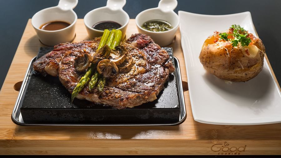 An image of a steak with sauces and a dish made of bread presented in an elegant manner - S Hotel Kingston, Jamaica