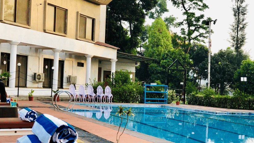 towels on the lounger with swimming pool in view - VITS Kamats Resort, Silvassa