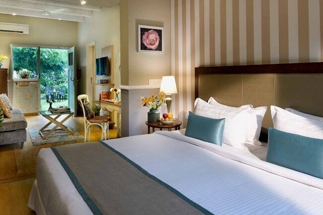 A bedroom with a large bed, wall mirror, and bedside tables with lamps at Karma Chalets. 