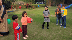 An outdoor scene with several people gathered on a green lawn