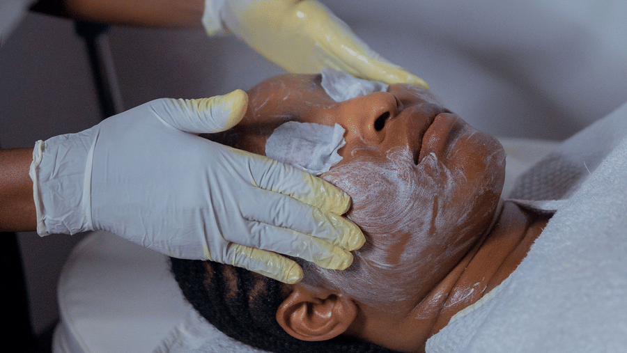 A guest receiving a relaxing facial treatment with a therapist applying skincare products at a wellness spa.