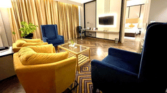 An image of a seating area with several sofas, centre table and a flat screen TV -  Hotel Polo Towers, Agartala