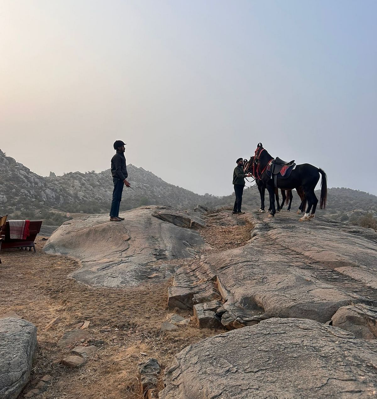 An image of horses on top a mountain with their caretakers - Utsav Camp Sariska