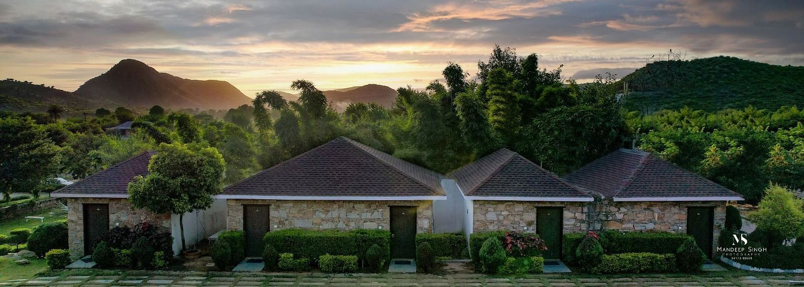 Facade of an accommodation with trees and mountains in the background at Valley by Grassfield.