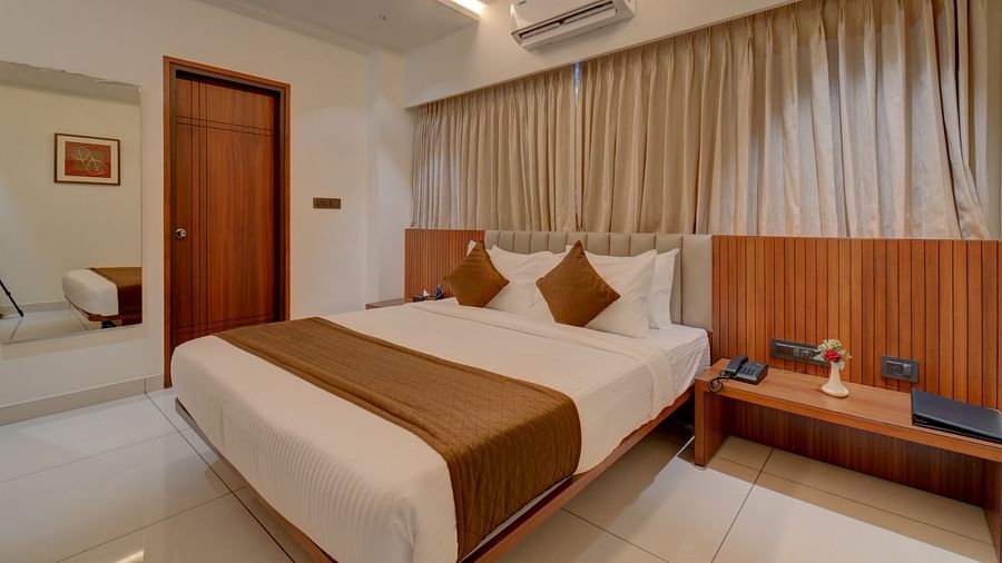 Image of a room with a bed and a door on the side at Hari Govindas, Siddappa Square.