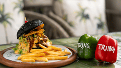 An image of a wooden plate with a burger, French fries, and two capsicums, each labelled Tring.
