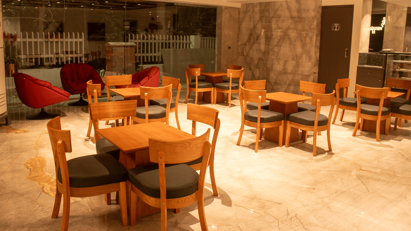 Indoor restaurant seating area with tables, chairs, and ceiling lights arranged in a grid pattern.