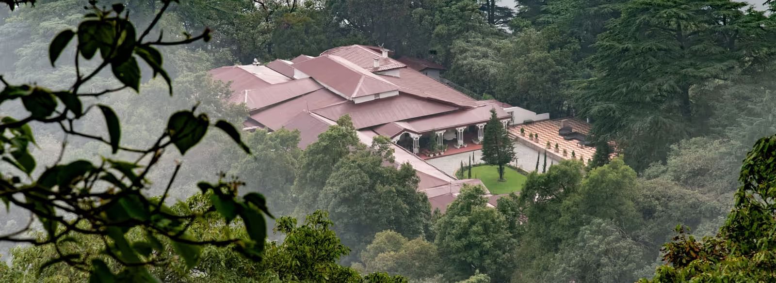 aerial view shot of The Claridges Nabha Residence in Mussoorie surrounded by lush green forest
