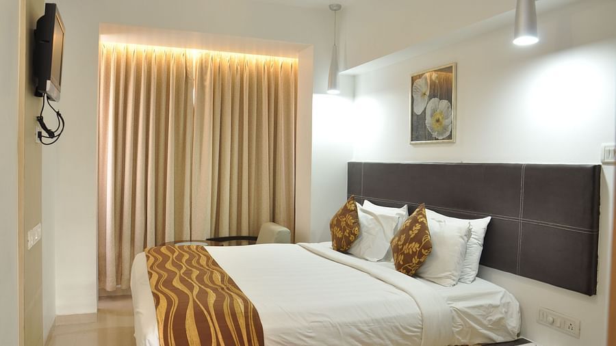 Premuim King Room with bed and a television in front of it at The Oriental Residency