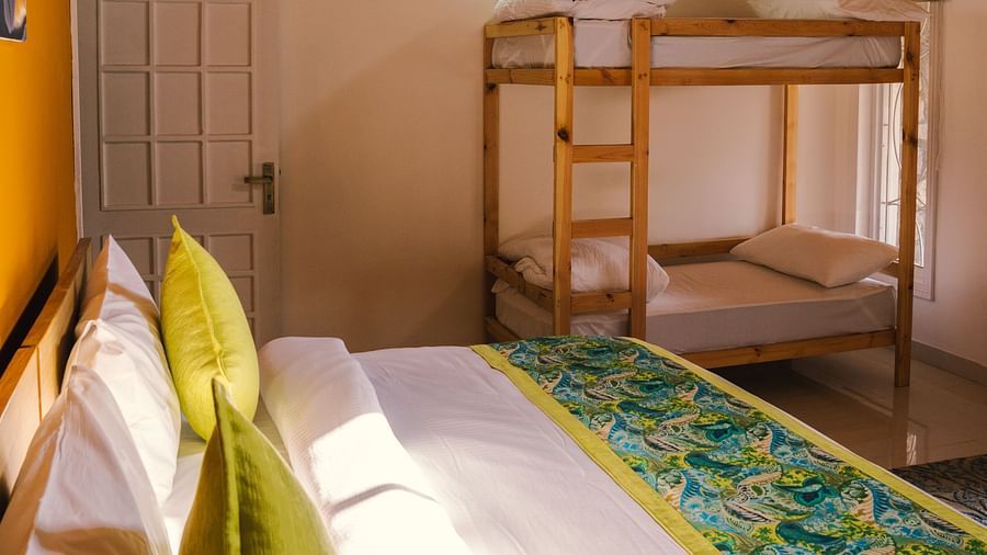 A side view of a neatly made bed with bunk beds to the side at BluSalzz Villas - The Green Roof, Bhimtal.
