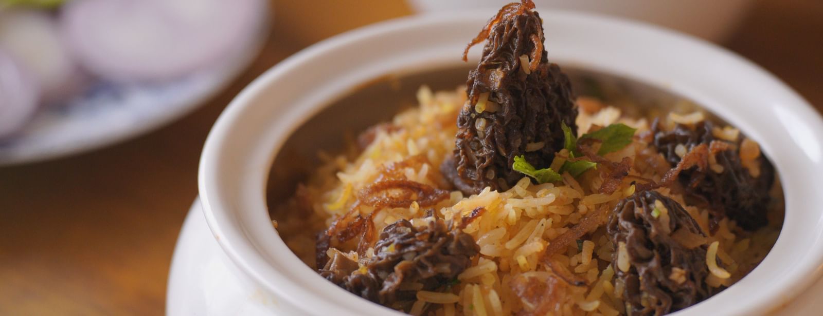 Close-up of a traditional Indian dish served in a white ceramic bowl - Mayfair Cafe & Suites, Dalhousie