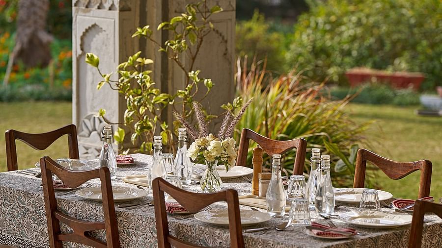 image of a dining table overlooking the lush green serene lawn at dev shree, deogarh