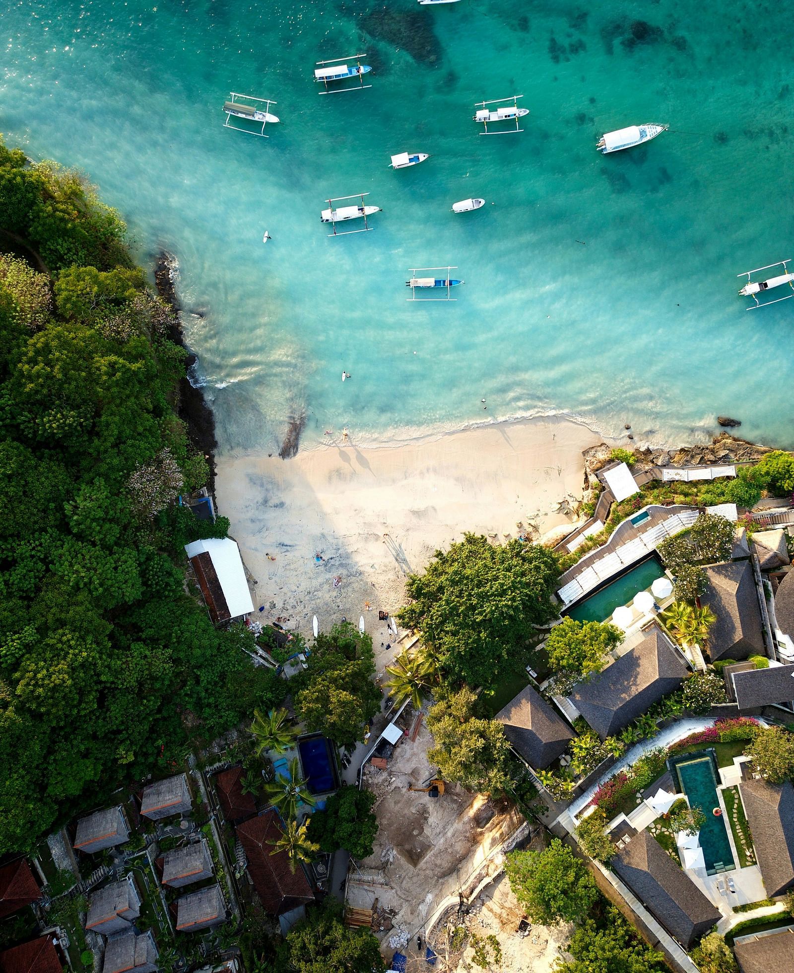 Aerial view of boats anchored near the shore and buildings along the coastline