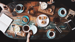 person-sitting-near-table-with-teacups-and-plates-2074130
