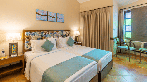 superior room in goa featuring twin beds and modern interiors