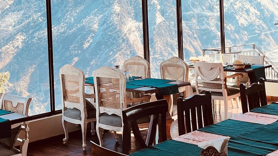 Image of dining area with tables and chairs with view of the mountains | Faraway Cottages, Auli