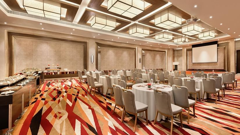 Conference setup with round tables and a buffet at the back at The Residency Towers Coimbatore