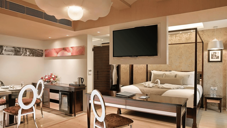 An intricately designed Suite at Barsana Boutique Hotel, Kolkata, featuring a spacious bed, dining space and a work desk.