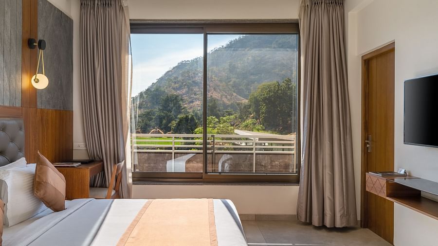 Enjoy the comfort of a king size bed and the scenic view through the balcony of the Superior Room at Stone Wood Hotel, Kumbhalgarh. For more details, explore images of Stone Wood Premier Kumbhalgarh to visualize the perfect stay.