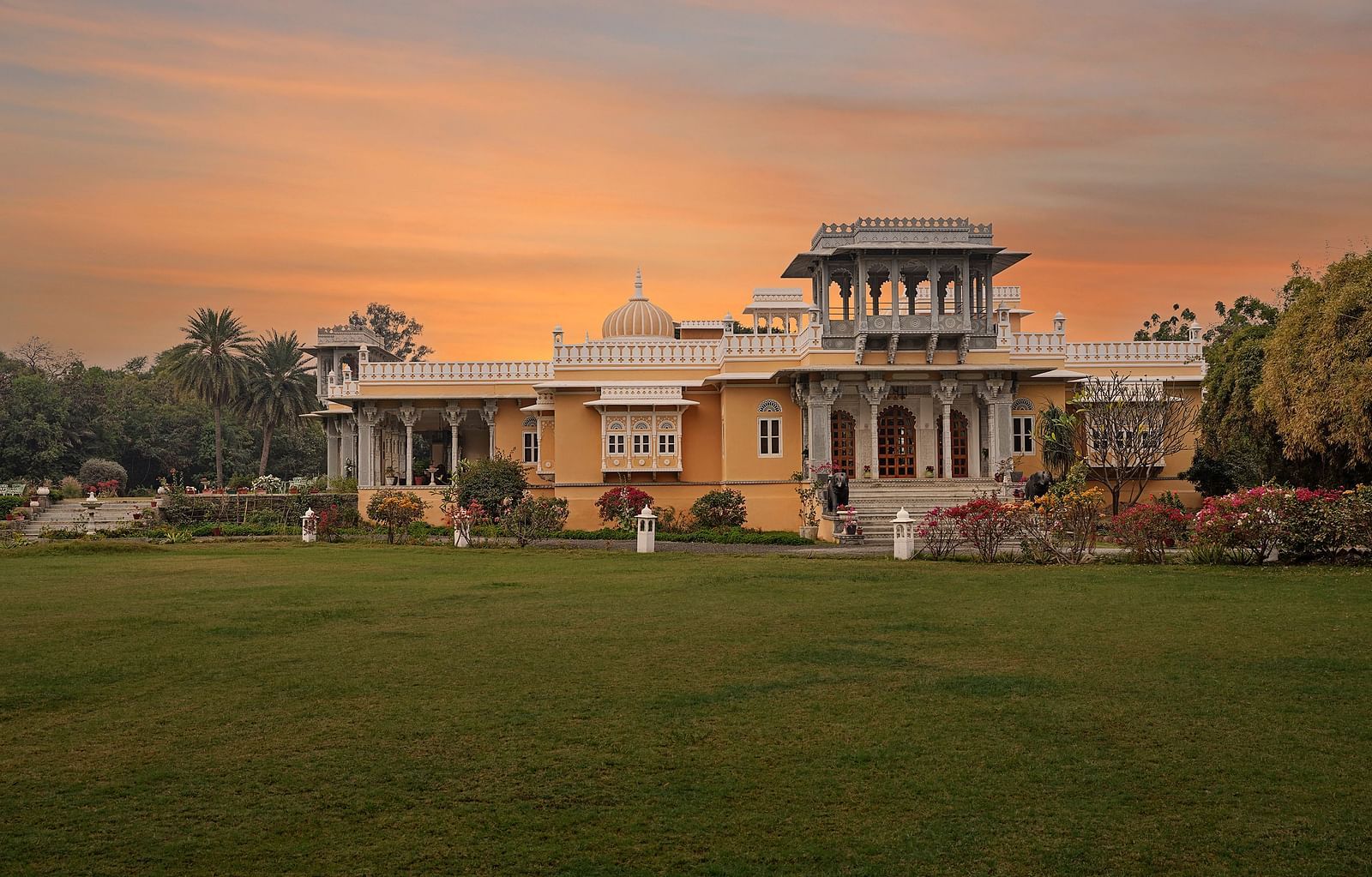 facade image of dev shree, deogarh with a beautiful sunset sky with orange hues in the background