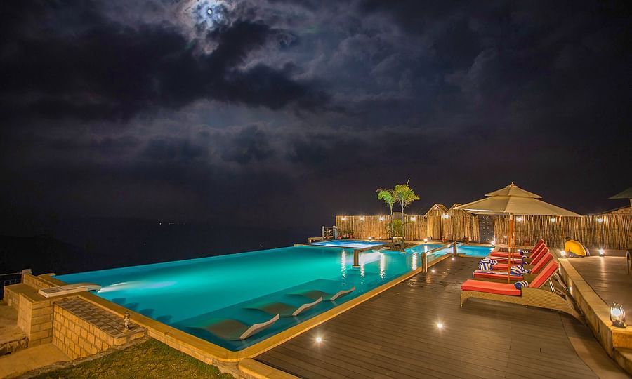 alt-text Nighttime poolside area with illuminated pool