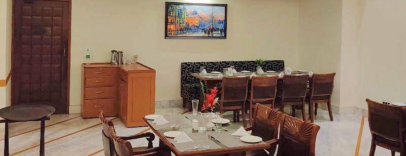 Corner view shot of a brightly lit dining area of the Gold Plate restaurant with central air-conditioning and a small cabinet in the corner of the restaurant - Hotel Gold, Panipat